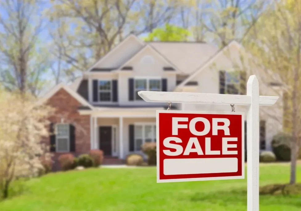 Red For Sale real estate sign in front of a suburban Ottawa house during spring, representing the best time to sell a home.